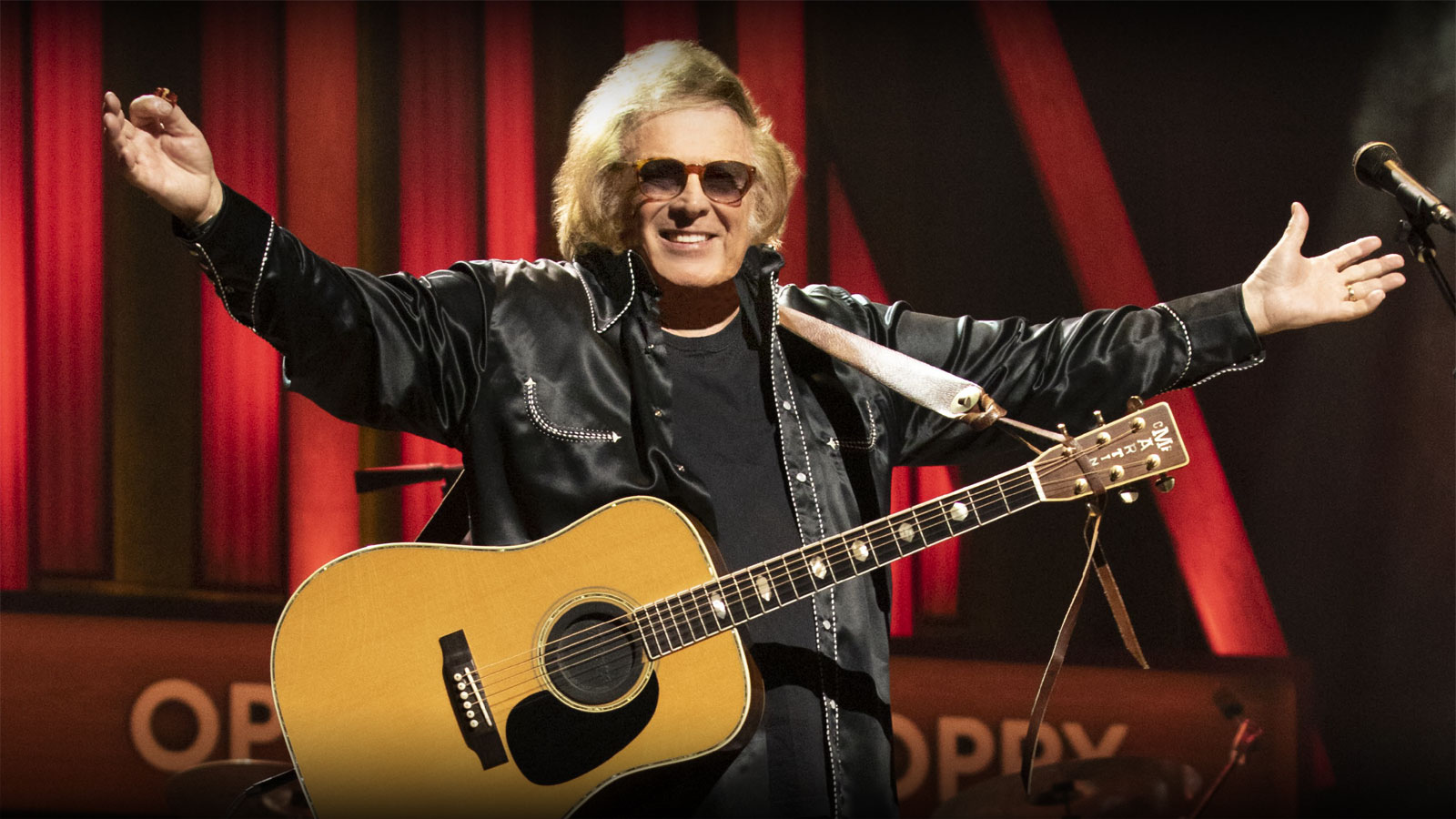 Don McLean with arms outstretched at the microphone