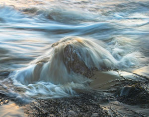 Photo of a wave crashing over rocks