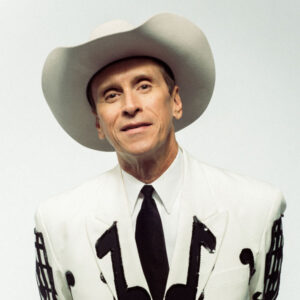Jason Petty dressed as Hank Williams in white cowboy attire.