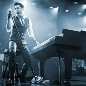 Frankie Moreno standing at the piano with a microphone