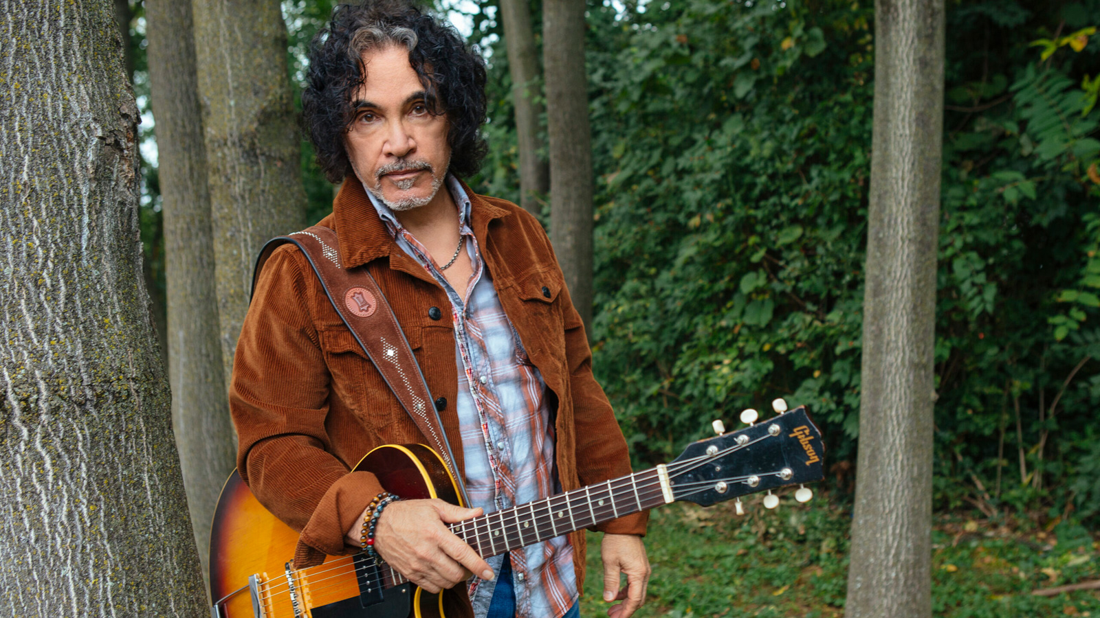 John Oates standing outdoors with his guitar