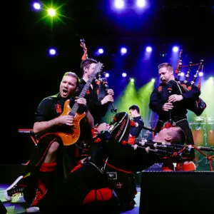 Rock bagpipers performing on stage.