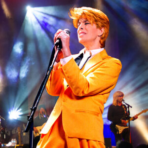 David Brighton performing in bright yellow suit as David Bowie.