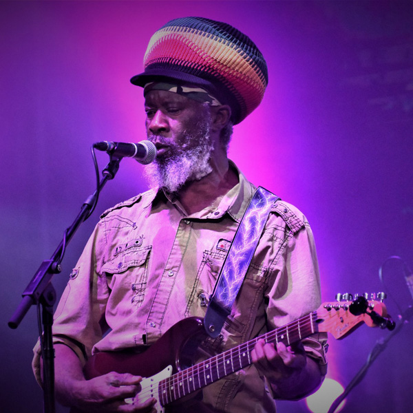 Ras Danny playing guitar on stage