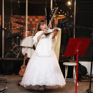Young girl playing violin in concert