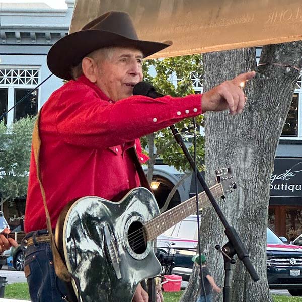 Monte Mills singing with his guitar on stage