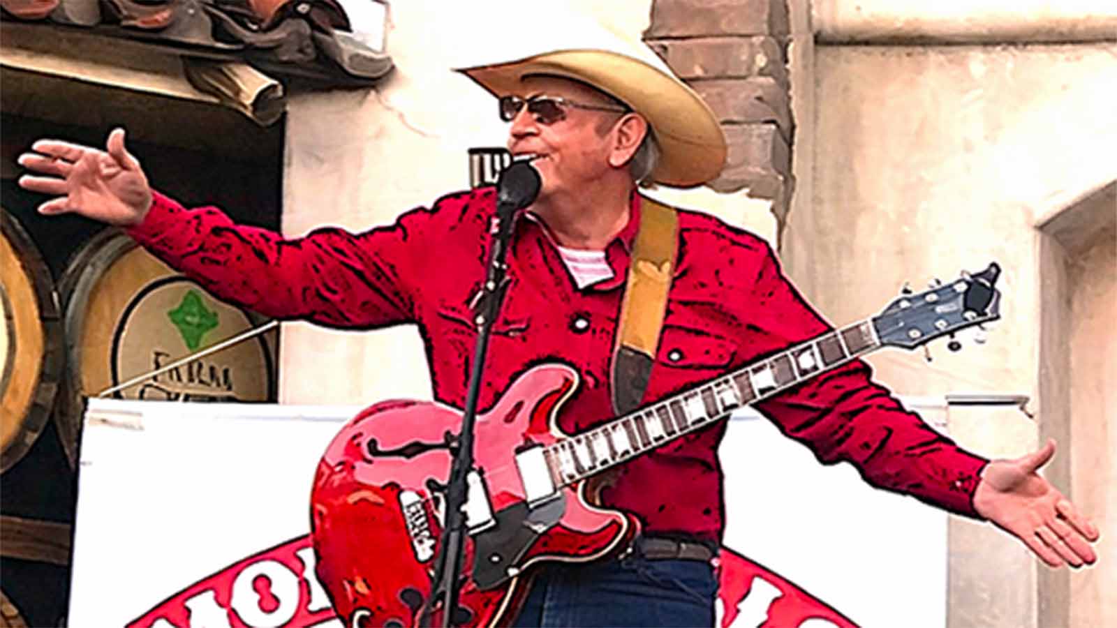 Monte Mills singing with his guitar on stage